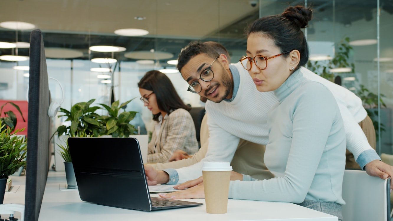 Professionals collaborating with laptops at a desk